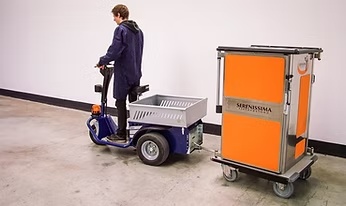 Powered vehicle connected to a food transport trolley